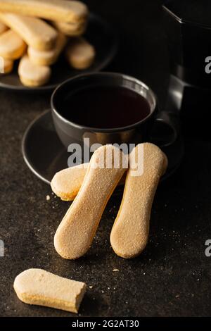 Italienischer Keks savoiardi. Süße Kekse. Biskuit-Kekse tiramisu auf schwarzem Tisch. Stockfoto