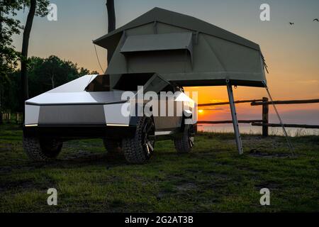 Tesla Cybertruck mit Zelt in einem Waldlager Stockfoto