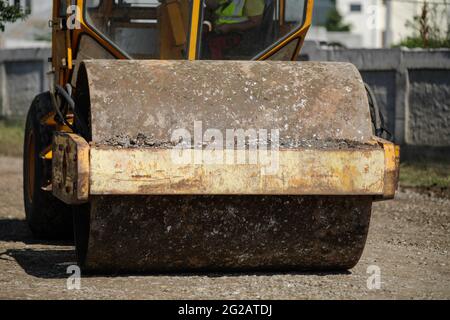 Details zur geringen Schärfentiefe (selektiver Fokus) mit einer schweren Vibrationswalze (Vibrationsverdichter, Verdichtungswalze) auf der Baustelle eines r Stockfoto