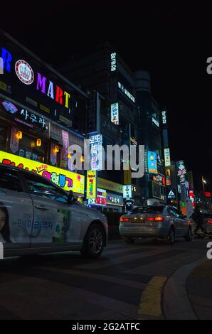 Busan, Südkorea - 23. März 2018: Vertikale Straßenansicht mit farbenfroher Werbebeleuchtung bei Nacht sind Menschen und Autos auf der Straße in Downto Stockfoto