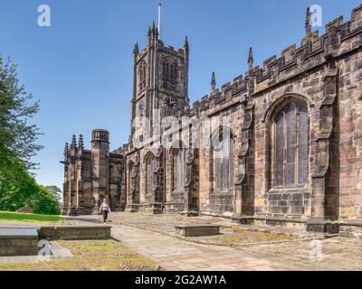 12. Juli 2020: Lancaster, Großbritannien - die Pfarrkirche St. Mary im Sommer, Frau, die vorbei geht. Stockfoto