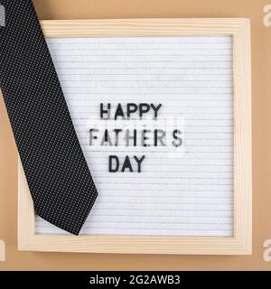 Briefbrett mit Glückwunschschriftzug Happy Father's Day und Accessoire Herrenkrawatte. Stockfoto