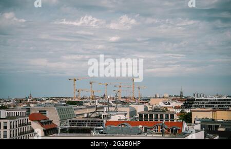 Eine große Baustelle mit vielen Kräne auf einem Fluss, an einem sonnigen, nebligen Tag in Berlin, Deutschland Stockfoto