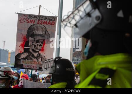 Bogota, Kolumbien. Juni 2021. Ein Polizeibeamter steht vor einem Schild mit der Aufschrift „Kolumbien ohne Polizei (ESMAD)“, als während der Überprüfungstreffen der Vereinten Nationen und der CIDH im Rahmen von regierungsfeindlichen Protesten in Kolumbien Demonstrationen vor den Eingang des Tequendama Hotels gingen, die zu mindestens 70 Toten in Polizeibrutalität und Unruhen führten Fälle während monatelangen Protesten am 9. Juni 2021 in Bogota, Kolumbien. Kredit: Long Visual Press/Alamy Live Nachrichten Stockfoto