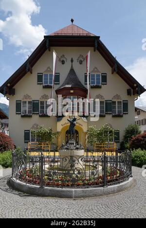 HALLSTAT, ÖSTERREICH - 08. Jan 2021: Typisch österreichisches Alpenhaus mit hellen Blumen auf dem Balkon Stockfoto