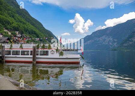 HALLSTAT, ÖSTERREICH - 08. Jan 2021: Typisch österreichisches Alpenhaus mit hellen Blumen auf dem Balkon Stockfoto