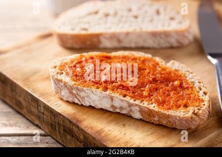 Toastbrot in Scheiben mit Sobrasada auf rustikalem Holztisch. Typisch mallorquinische Küche in Spanien. Stockfoto