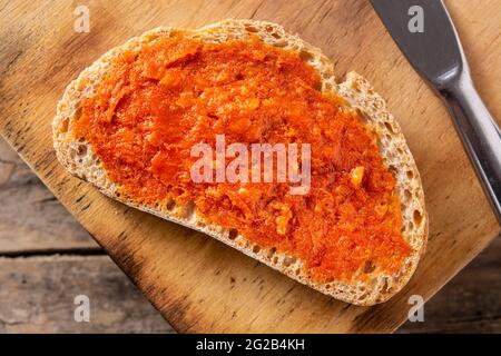 Toastbrot in Scheiben mit Sobrasada auf rustikalem Holztisch. Typisch mallorquinische Küche in Spanien. Stockfoto