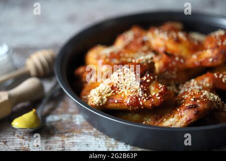 Gebackene Hähnchenflügel mit Sesam in einer Pfanne. Junk Food. Köstliche Büffelflügel. Stockfoto