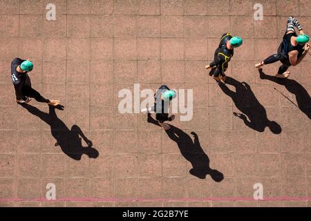 London Triathlon 2018-Athleten werfen lange Schatten, während sie zum Start des Schwimmrennens in London, Großbritannien, gehen Stockfoto