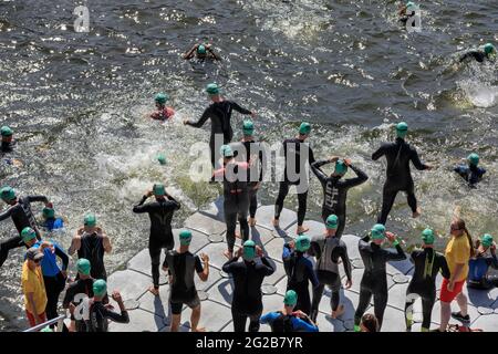 Männliche Triathleten springen beim Schwimmwettbewerb beim AJ Bell London Triathlon 2018, Großbritannien, ins Wasser Stockfoto