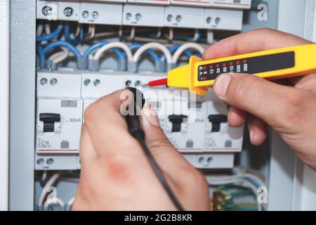 Elektriker mit Multimeter-Prüfspitze an einer elektrischen Schaltanlage ca. Stockfoto