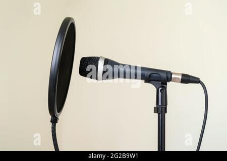 Professionelles Studiomikrofon mit Pop-Shield auf einem Ständer in einem Heimmusikstudio. Niemand Stockfoto