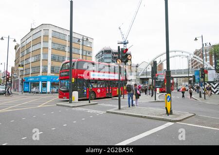 Roter Doppeldecker-Londoner Bus auf der Shoreditch High Street und Fußgänger warten an der Ampel in East London England, Großbritannien, KATHY DEWITT Stockfoto