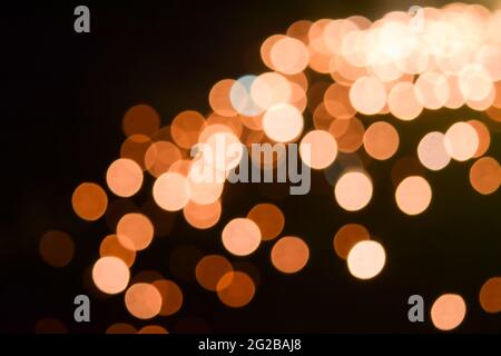 Abstraktes Bokeh von Licht für Hintergrund von Orange farbigen Schattierungen mit schwarzem Hintergrund. Stockfoto