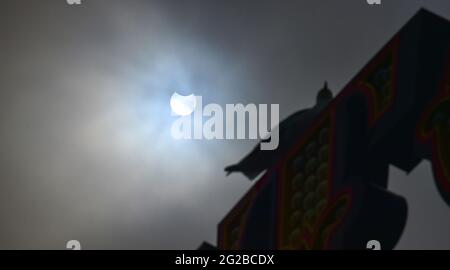 Brighton UK 10. Juni 2021 - EINE partielle Sonnenfinsternis der Sonne findet hinter dem Brighton Palace Pier während eines nebligen Morgens an der Südküste statt : Credit Simon Dack / Alamy Live News Stockfoto