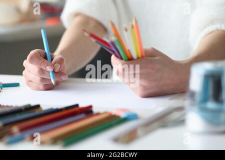 Damen Hände, mehrfarbige Bleistifte zum Erstellen von Skizzen von modischer Kleidung Stockfoto