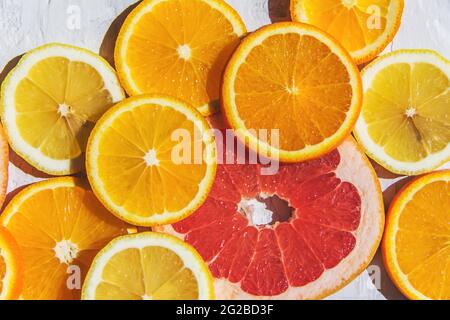 Zitrusfrüchte. Orange, Zitrone, Grapefruit, auf trendigem Steinhintergrund Draufsicht, flach liegend Stockfoto