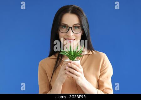 Frau hält Blumentopf mit Pflanze in den Händen Stockfoto