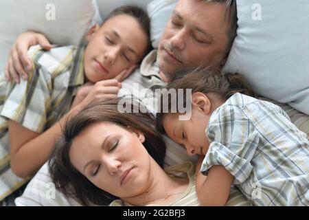 Porträt eines schlafenden Bruders, einer Schwester und eines Vaters im Zimmer Stockfoto