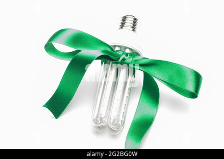 Umweltfreundliche Glühbirne mit grünem Band als Geschenk, spart Energie und Geld. LED-Lampe, energiesparend. Ein gutes Geschenk ist grüne und ökologische Energie. Stockfoto