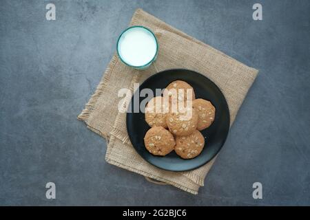 Blick von oben auf Kekse und ein Glas Milch auf dem Tisch Stockfoto