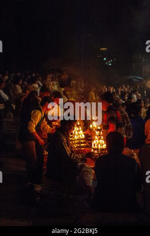 Zünden des Deepams für die Ganga Arti Zeremonie im Dashashwarmedh Ghat in Varanasi, Indien bei Nacht, warmes Kerzenlicht Stockfoto