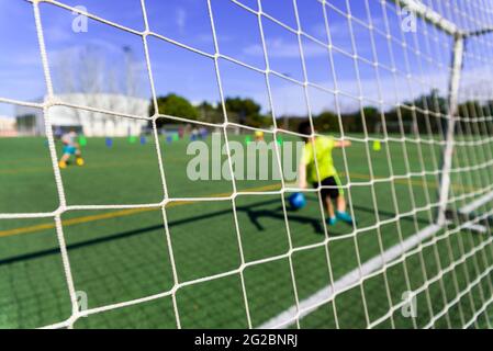Fußballspieler in einem Tor versucht, einen Ball zu stoppen, Hintergrund mit Kopierraum für Text. Stockfoto