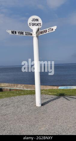 Berühmter Wegweiser in John O'Groats, dem nördlichsten Punkt auf dem Festland, der Entfernungen nach New York, Edinburgh, Land's End, Orkney und Shetla anzeigt Stockfoto