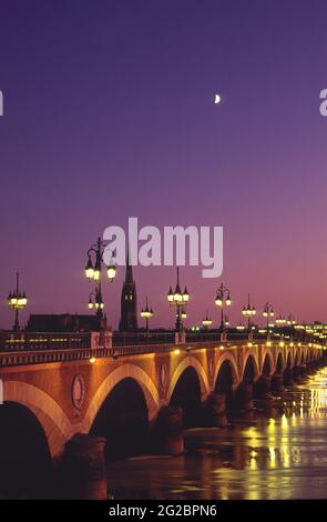 FRANKREICH. GIRONDE (33) STADT BORDEAUX. DIE BRÜCKE PONT DE PIERRE IN DER DÄMMERUNG (IM HINTERGRUND DER GLOCKENTURM VON SAINT MICHEL) Stockfoto