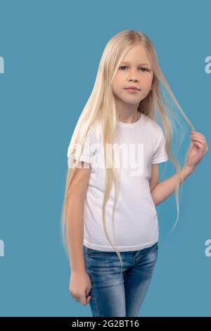 Hübsches Mädchen, das ihr Haar berührt Stockfoto