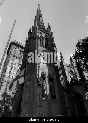 Nordseite der Trinity Church im Finanzviertel von Lower Manhattan. Starke vertikale Weitwinkelaufnahmen. Stockfoto