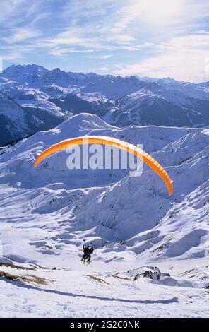 FRANKREICH, SAVOIE (73) TARENTAISE-TAL, VANOISE-GEBIRGE, SKIGEBIET LA PLAGNE, PARAGLIDING UND IM HINTERGRUND DAS SKIGEBIET COURCHEVEL Stockfoto