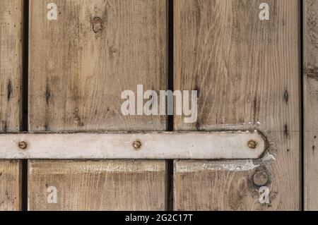 Teil einer sehr alten Holztür mit einer weiß lackierten Halterung Stockfoto