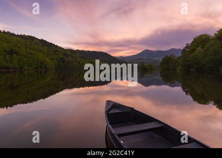 Boot am See. Majestätischer Sonnenuntergang am Chambon-See im Regionalen Vulkannatur-Park Auvergne, Frankreich. Schöne Natur Hintergrund. Reisekonzept. Stockfoto