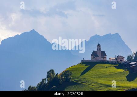 Berglandschaft mit Dörfern von Colle Santa Lucia mit Kirche in Dolomiten, Südtirol, Italien Stockfoto