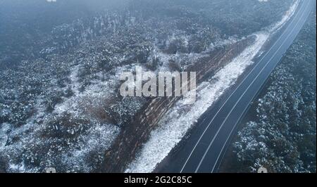 Sydney, Australien. Juni 2021. Am Blue Mountain westlich von Sydney, Australien, wird bei schneebedecktem Wetter am 10. Juni 2021 eine leere Straße gesehen. Sydney verzeichnete am Donnerstag seinen kältesten Tag seit 37 Jahren, als eine antarktische Kälte über dem australischen Bundesstaat New South Wales (NSW) verweilte. Quelle: Hu Jingchen/Xinhua/Alamy Live News Stockfoto