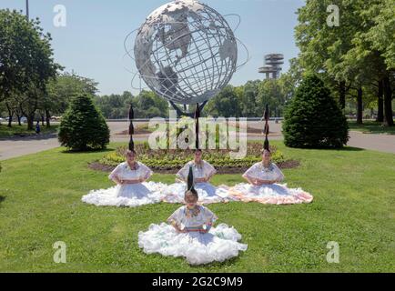 Posierte Foto einer Gruppe von paraguayischen amerikanischen Volkstänzern in einheimischen Kostümen mit der Unisphere im Hintergrund. Stockfoto