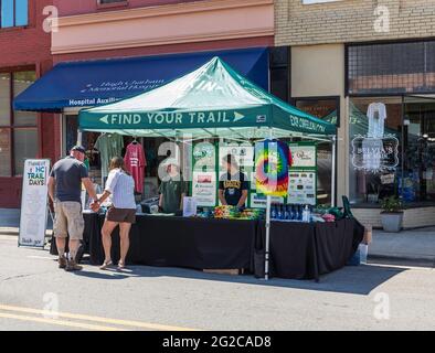 ELKIN, NC, USA-5. JUNI 2021: Ein Stand auf dem City Holiday Event mit Informationen zu den North Carolina Trail Days. 5 Personen. Horizontales Bild. Stockfoto