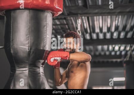 Junge dunkelhäutige Boxerin, die in einem Fitnessstudio trainiert Stockfoto