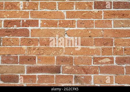 Strukturierte rote Ziegelwand aus alten Steinen. Fragment einer alten Ziegelmauer. Verwitterte Wand Stockfoto