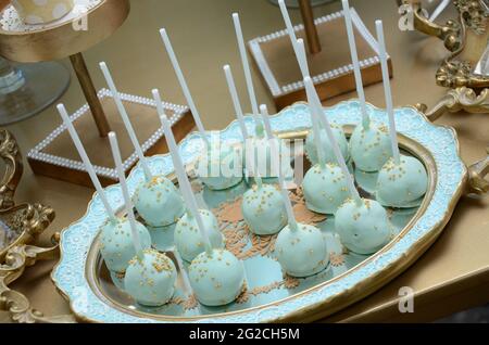 Babyblaue Cakepops.der Konditor schmückt Cake Pops mit Satinbändern Stockfoto