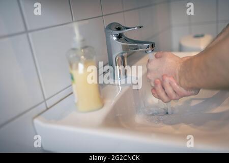 Mann waschen Hände im Badezimmer Stockfoto