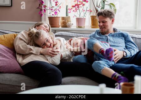 Eltern mit Kindern sitzen auf dem Sofa Stockfoto