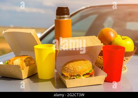 Mittagessen in der Natur auf der Motorhaube des Autos nach einer langen Reise. Stockfoto