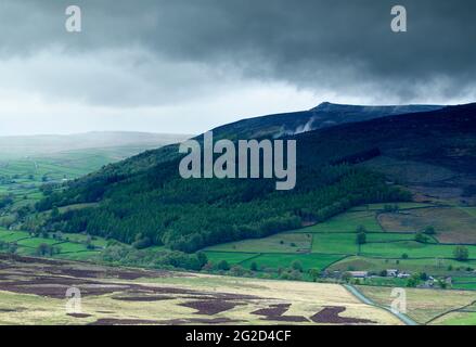 Landschaftlich reizvolle Landschaft (Wharfedale Valley, Simon's Seat Peak, hohe Fjells, Regen fällt auf die Hügel, dunkler wolkig Himmel) - Yorkshire Dales, England, Großbritannien. Stockfoto