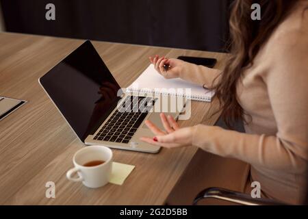 Mittelteil der Geschäftsfrau, die am Besprechungstisch sitzt Stockfoto