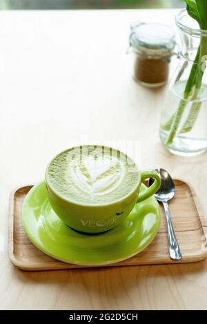 Matcha Latte mit Herz in einer grünen Tasse in einem Café Stockfoto