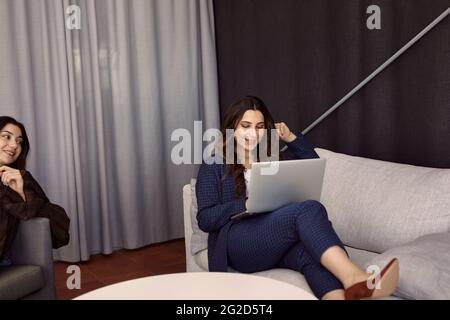 Geschäftsfrau mit Laptop auf sofa Stockfoto
