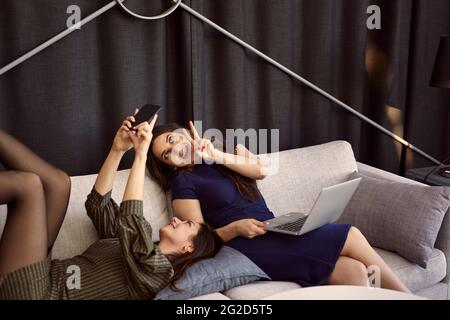 Geschäftsfrauen nehmen Selfie auf dem Sofa Stockfoto